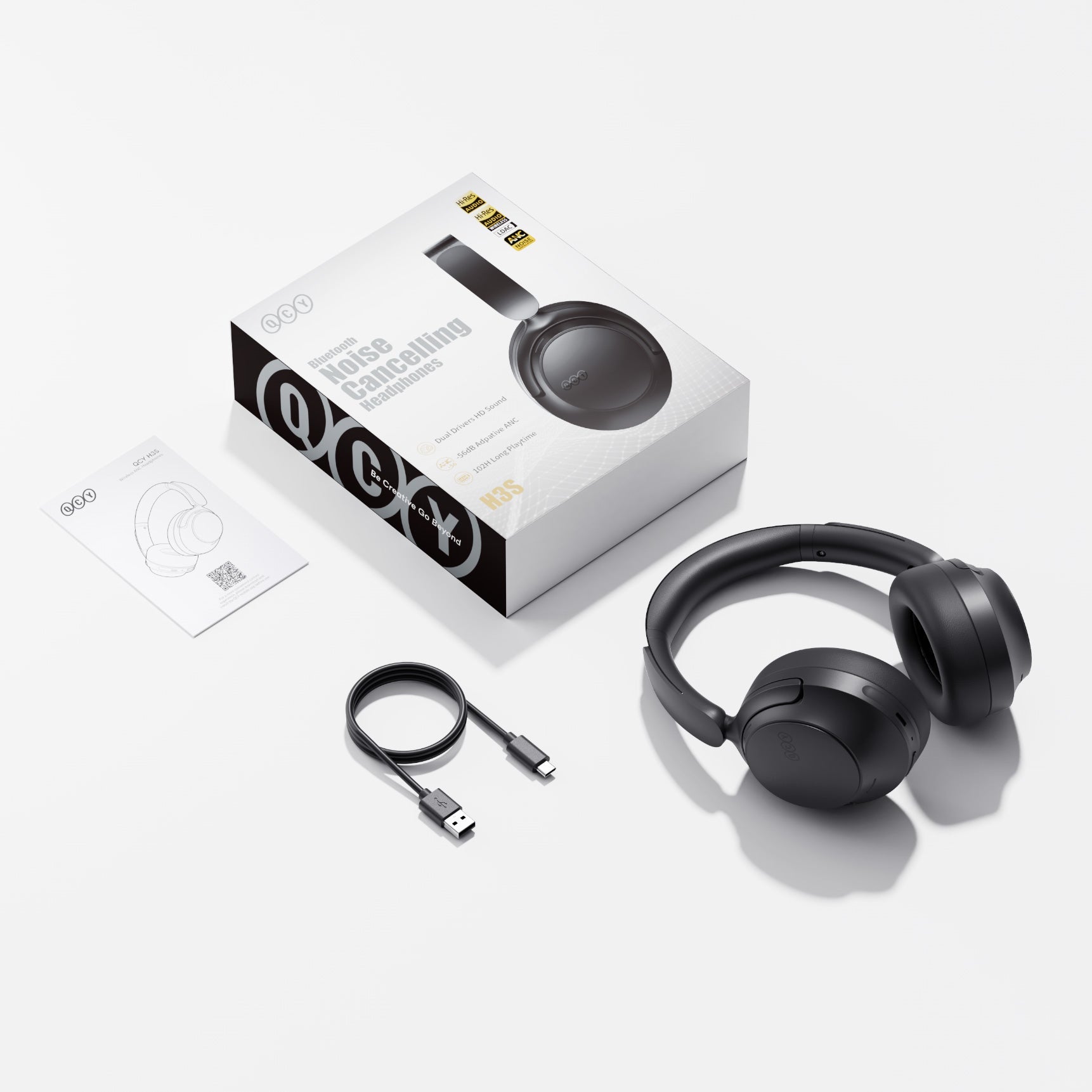 Auriculares QCY H3S Bluetooth con cancelación de ruido en negro, con cable de carga USB-C y manual.
