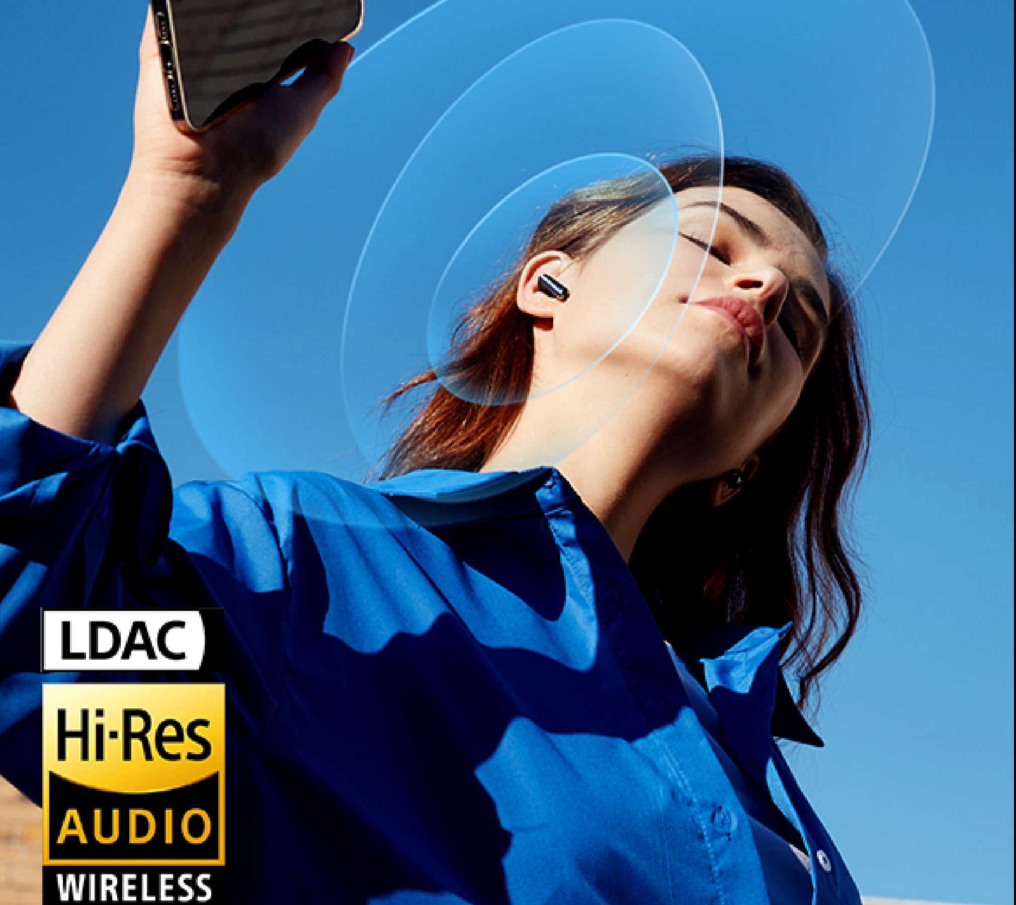 Mujer con auriculares inalámbricos Hi-Res Audio bajo un cielo azul, disfrutando de música mediante la tecnología inalámbrica LDAC.
