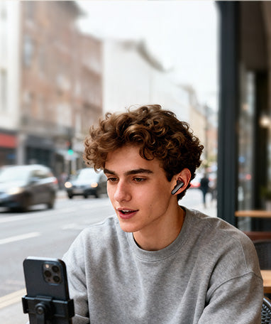 Joven con auriculares inalámbricos y smartphone en la ciudad