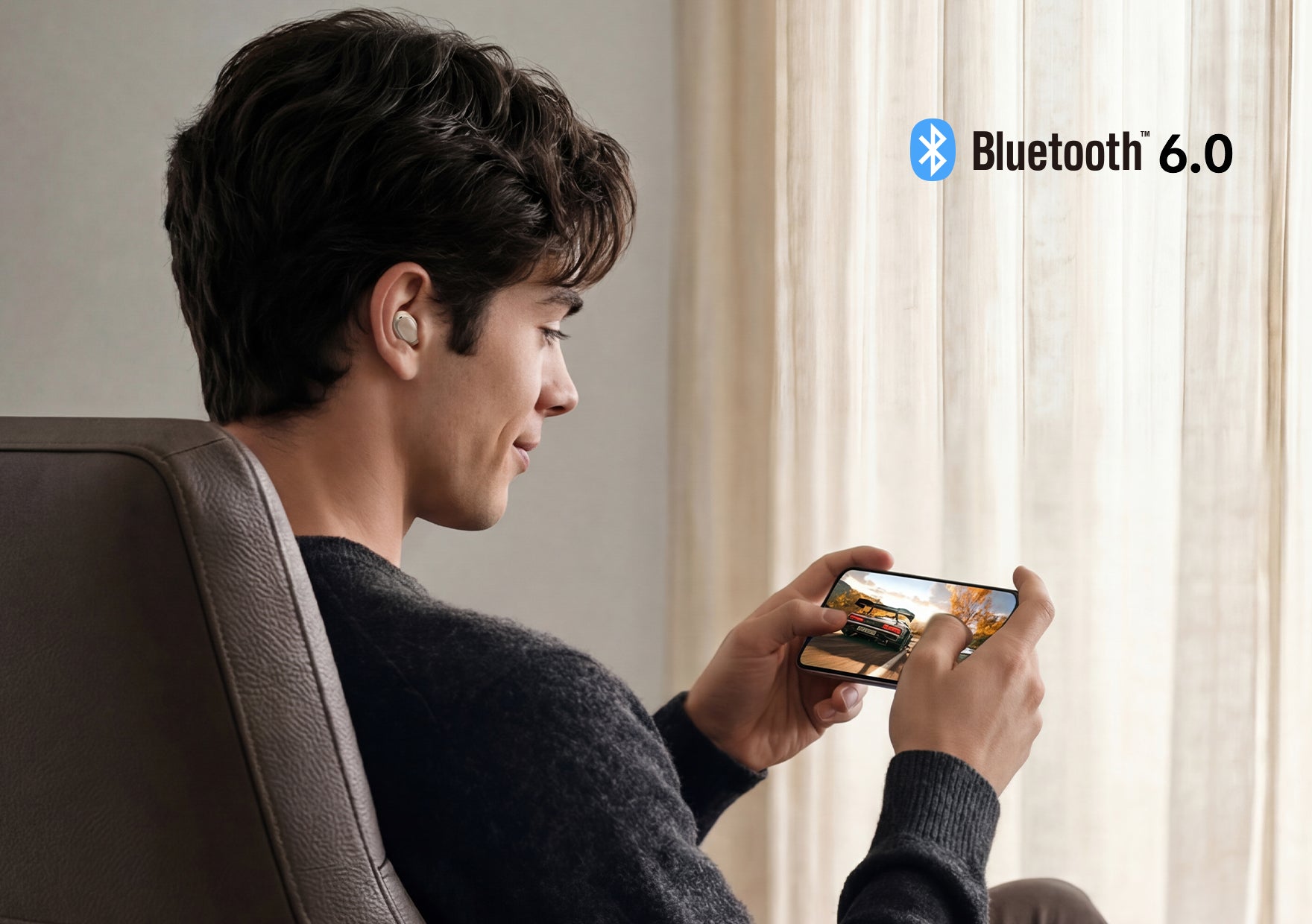 Hombre con auriculares Bluetooth 6.0 juega en smartphone: tecnología moderna para entretenimiento inalámbrico
