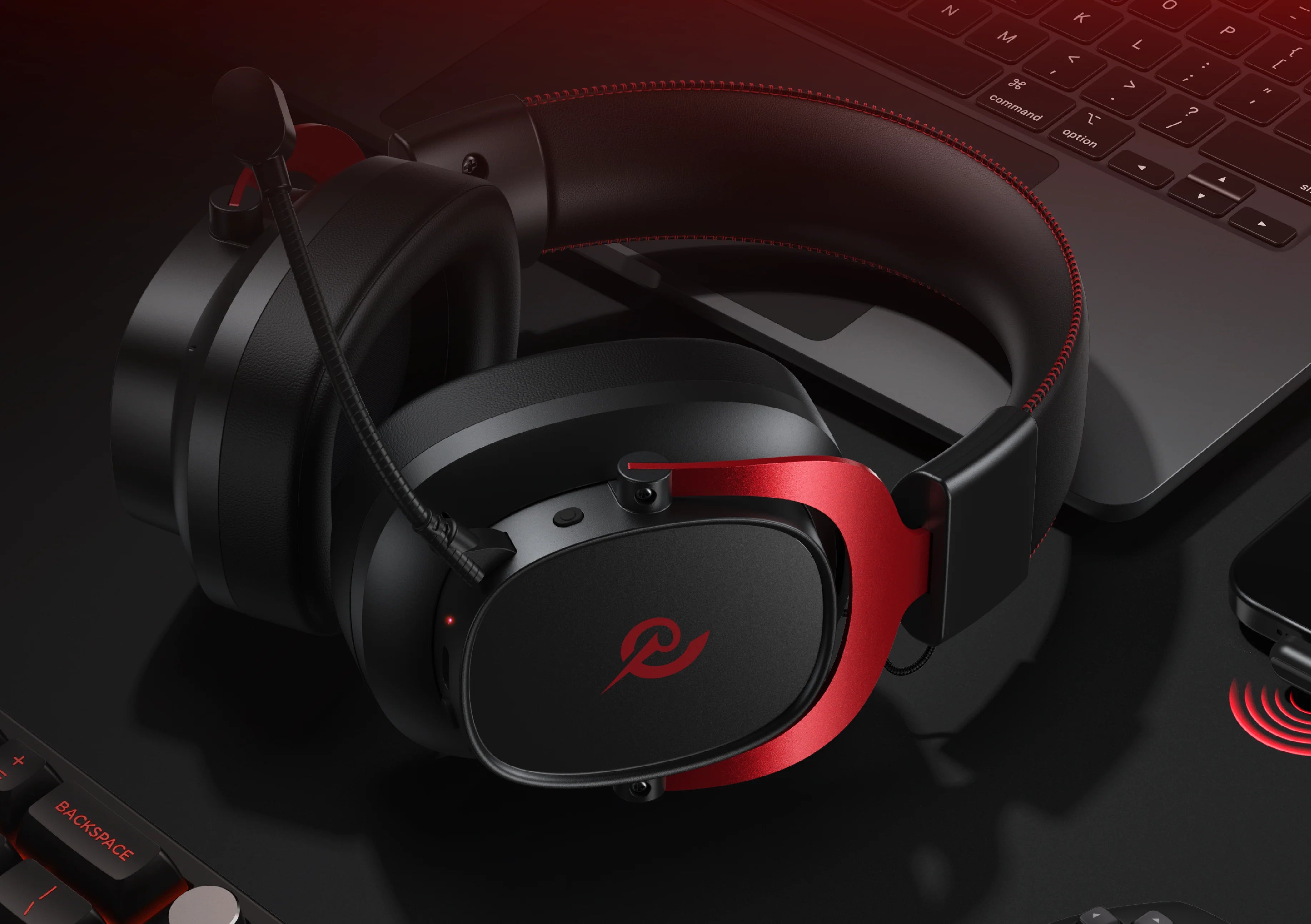 Auriculares para juegos con acento rojo y micrófono, colocados sobre un portátil, para una experiencia de audio óptima al jugar.