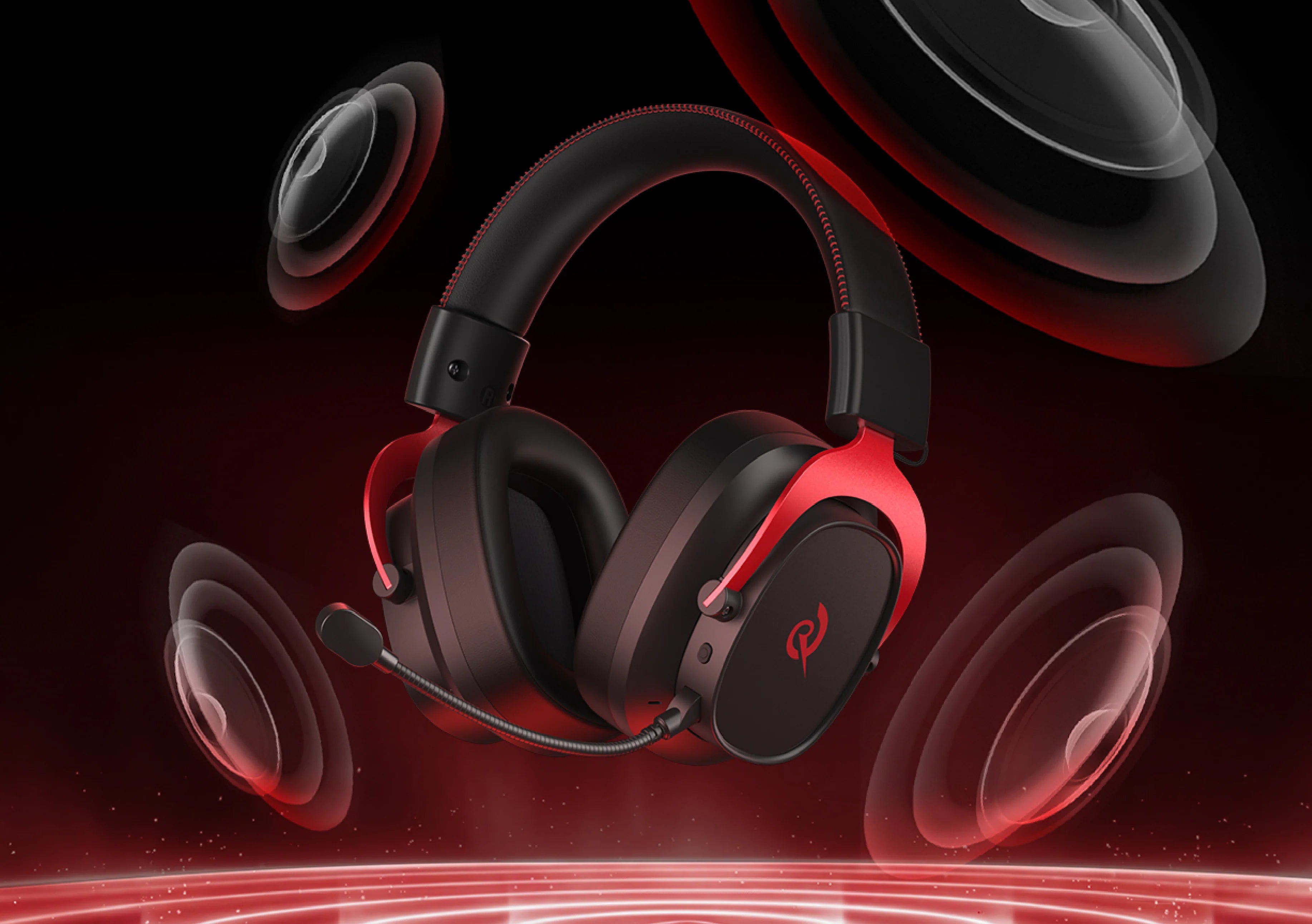 Auriculares de juego negros con acentos rojos y micrófono, rodeados de altavoces dinámicos sobre un fondo oscuro.