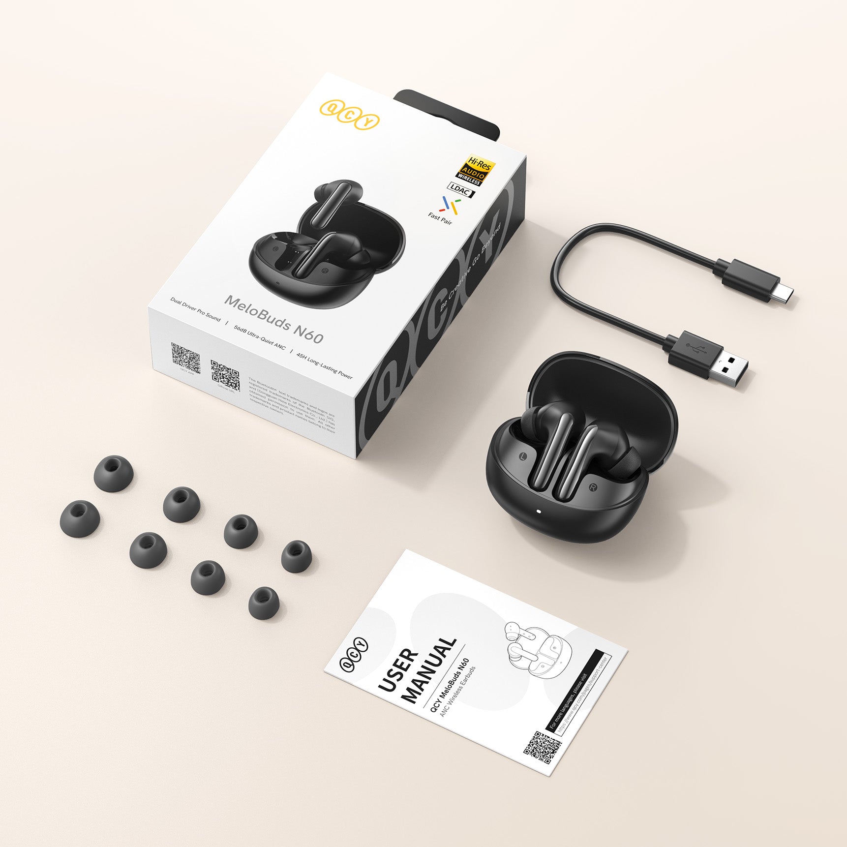 Auriculares inalámbricos QCY MeloBuds N60 con estuche de carga, cable USB, almohadillas de repuesto y manual de instrucciones sobre fondo claro